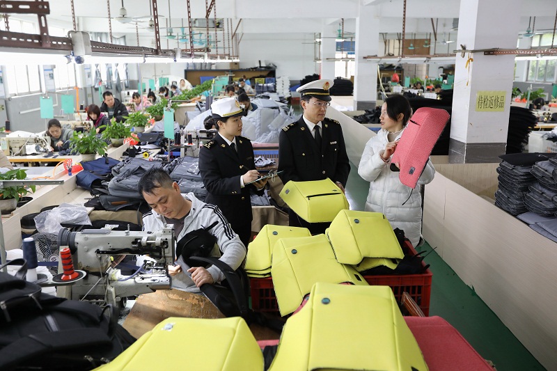 图为:广州海关所属花都海关关员在企业车间调研箱包生产和出口情况(周正森摄) 图为:广州海关所属花都海关关员在企业车间调研箱包生产和出口情况(周正森摄)